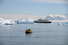 20A Zodiac Coming In To Land On Cuverville Island With Brabant Island And The Quark Expeditions Antarctica Cruise Ship Beyond